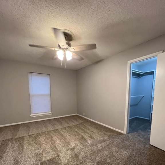 an empty room with a ceiling fan and a closet