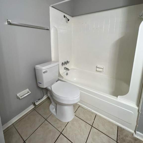 an empty bathroom with a toilet and a tub