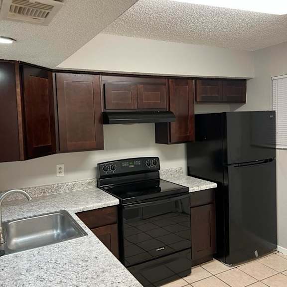a kitchen with black appliances and granite counter tops