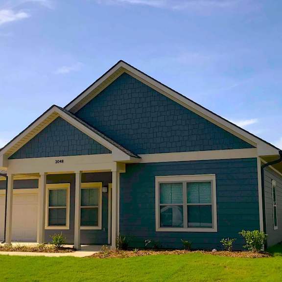 a blue house with a lawn in front of it