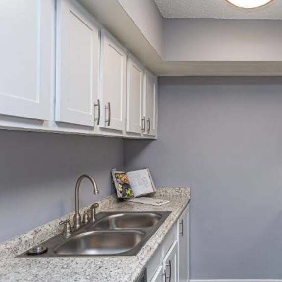 a kitchen with a black stove top oven and white cabinets.