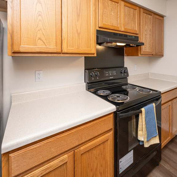 a black stove top oven with a blue towel hanging on it.