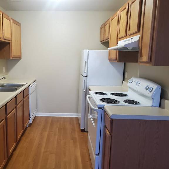 a kitchen with wooden cabinets and a white refrigerator.