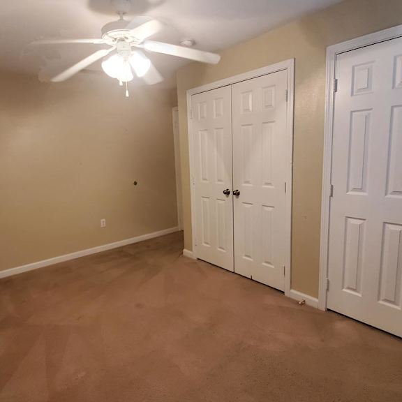 a room with a ceiling fan and two doors.