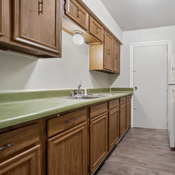 a kitchen with wooden cabinets and a white stove top oven.