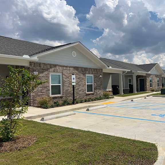 a parking lot in front of a building with a fire hydrant on the right.