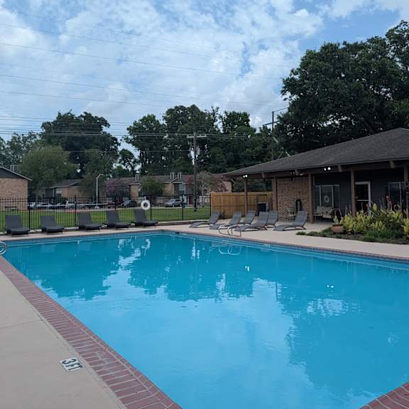 a large swimming pool with a red brick border.