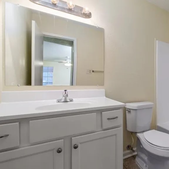 a white toilet sits next to a sink in a bathroom.