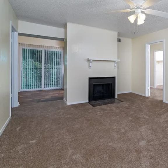 a living room with a fireplace and a ceiling fan.
