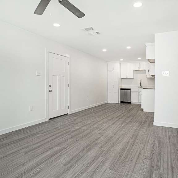 a spacious room with a ceiling fan and lighting fixtures.