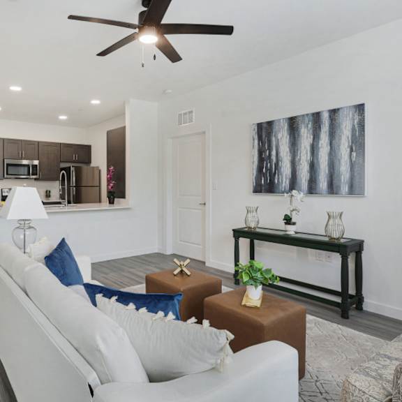 a living room with a white couch and a ceiling fan.
