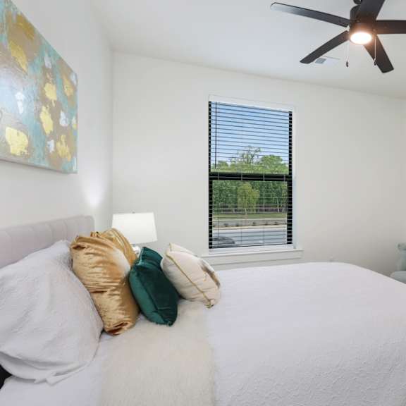 a bedroom with a large bed and a ceiling fan.