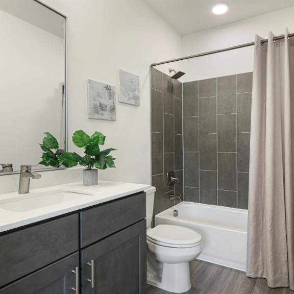 a bathroom with a white toilet and a shower with a beige curtain.