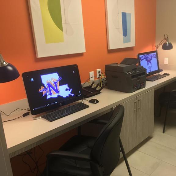 a workspace with a laptop, a desktop computer, and a printer on a white desk.