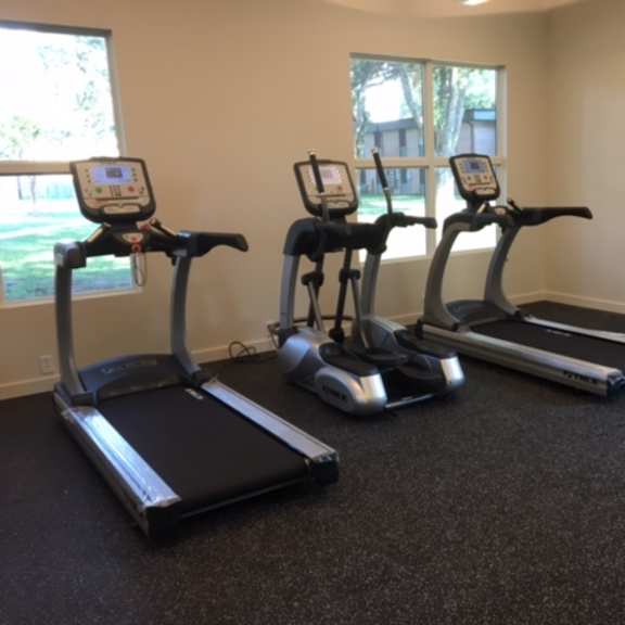 three exercise machines are lined up in a room.