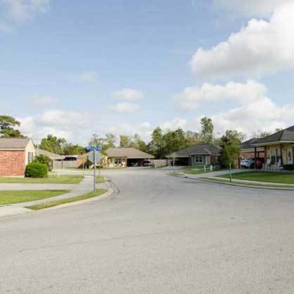 a street view of a residential area with houses and a clear sky.