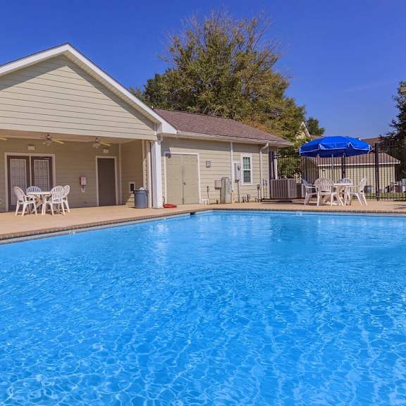 a house with a blue pool in front.