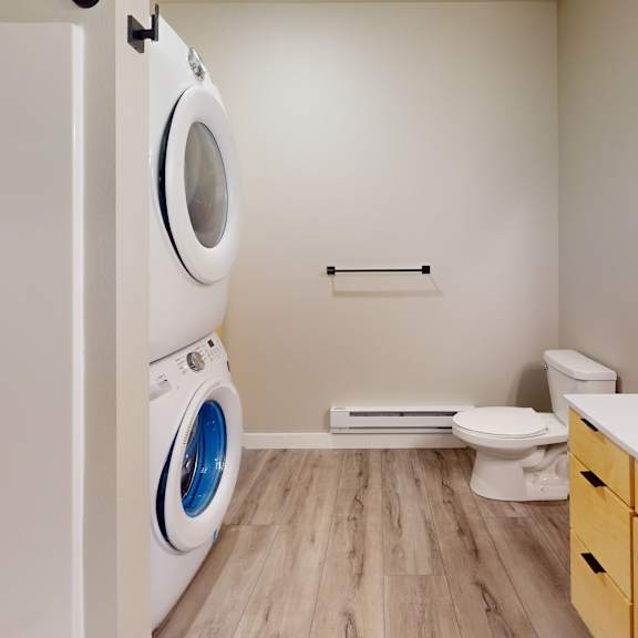 a modern bathroom with a washer and dryer built into the wall.
