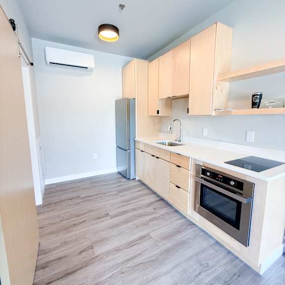 a kitchen with wooden cabinets and a stove top oven.