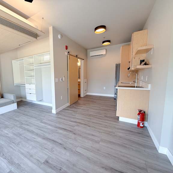 a living room with a grey sofa and a grey floor.