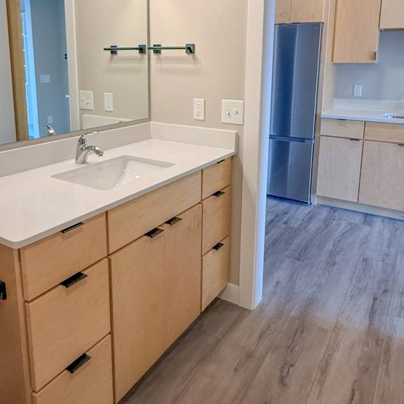 a bathroom with a sink, mirror, and wooden cabinets.