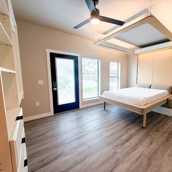a bedroom with a bed, a window, and a ceiling fan.