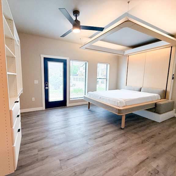a bedroom with a bed, dresser, and window.