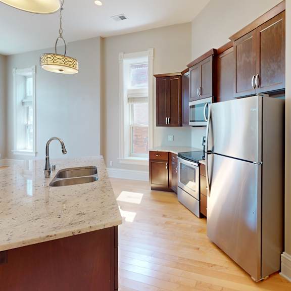 a kitchen with stainless steel appliances and a marble counter top