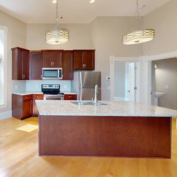 a kitchen with a marble counter top and wooden cabinets