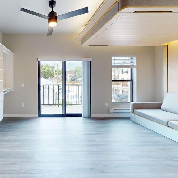 a modern living room with a sliding glass door leading to a balcony.
