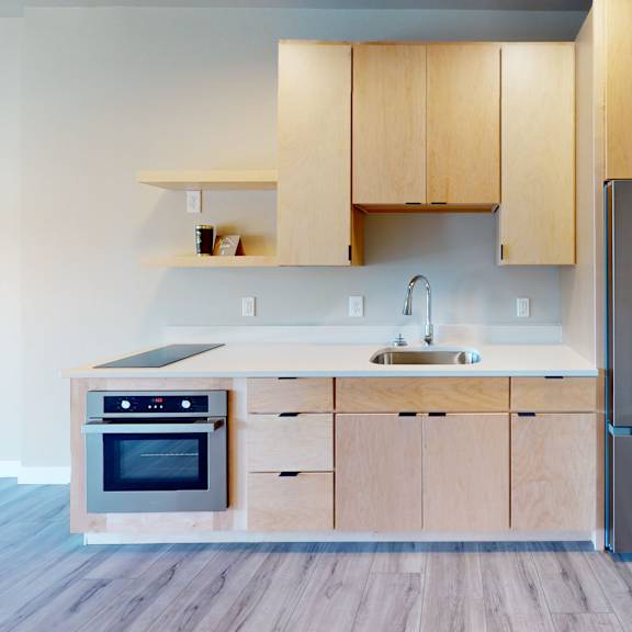 a kitchen with wooden cabinets and a stainless steel refrigerator.