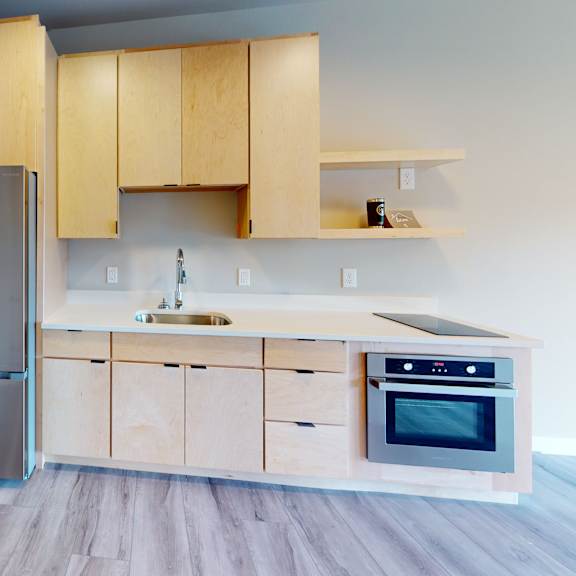 a kitchen with wooden cabinets and a stainless steel refrigerator.