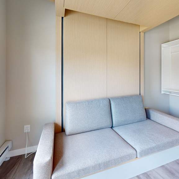 a grey couch with a white drawer unit to the right.