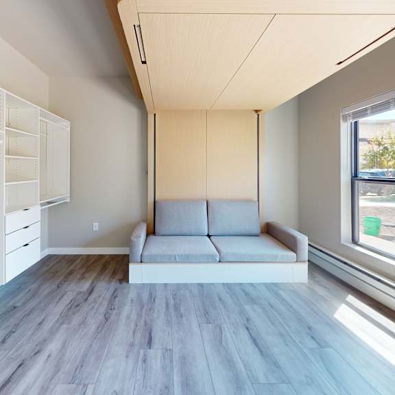 a modern living room with a grey floor and white walls.