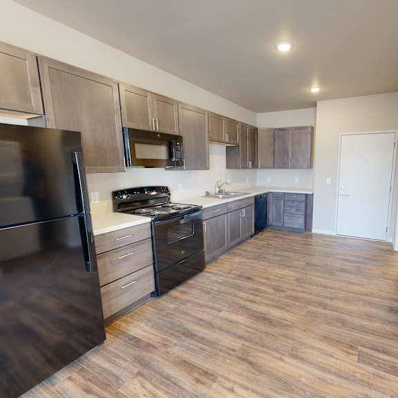 a kitchen with wood flooring and stainless steel appliances and