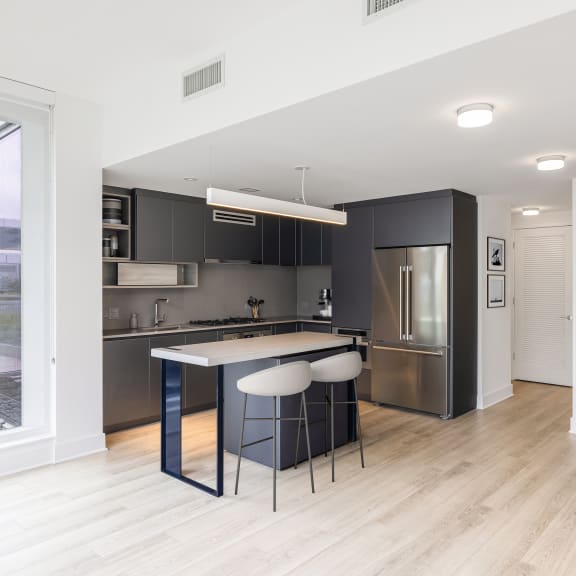 Thumbnail 2 of 2 a kitchen with an island and stools in a 555 waverly unit