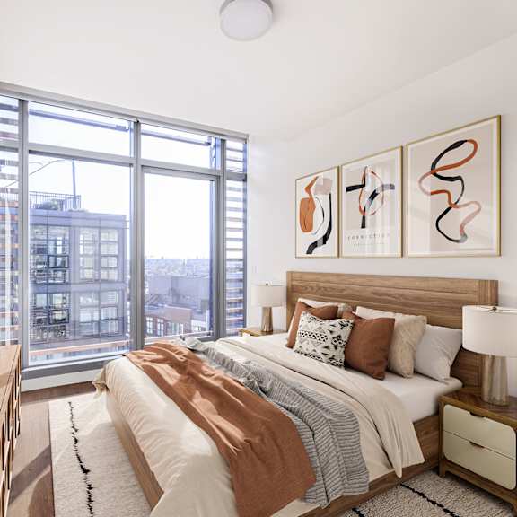 a bedroom with a large window and a bed with a wooden headboard