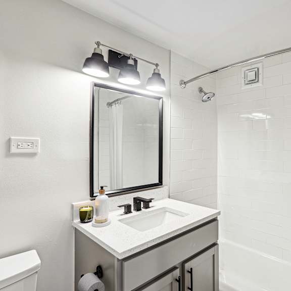 Thumbnail 9 of 13 a bathroom with a sink and a shower and a mirror