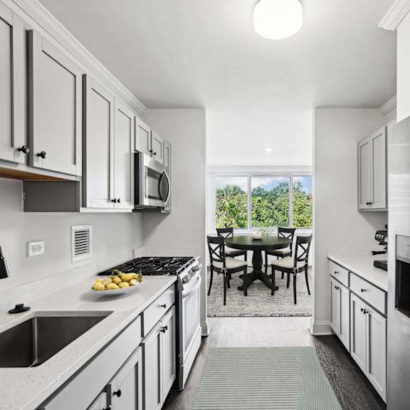 Thumbnail 2 of 13 a kitchen with white cabinets and stainless steel appliances and a stainless steel refrigerator