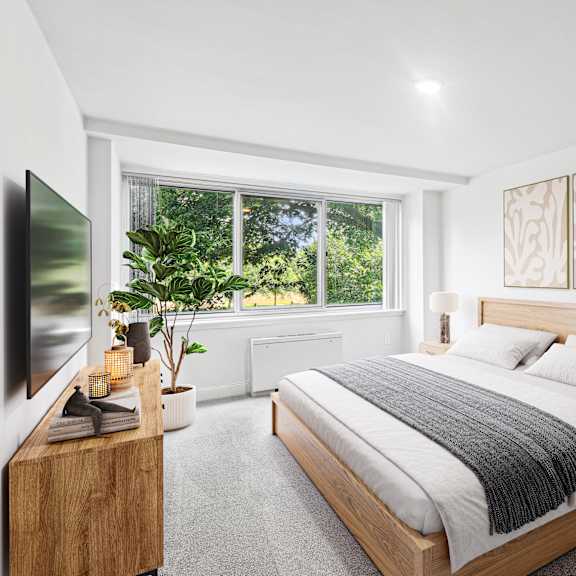 Thumbnail 7 of 13 a bedroom with a bed and a large window