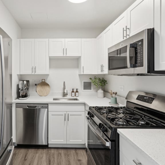 Thumbnail 4 of 7 a kitchen with stainless steel appliances and white cabinets