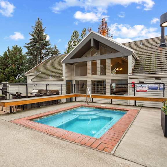 A swimming pool in a backyard with a house in the background.