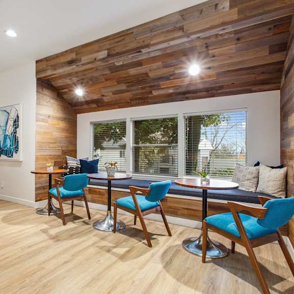A kitchen with a wooden ceiling and a dining table with chairs.