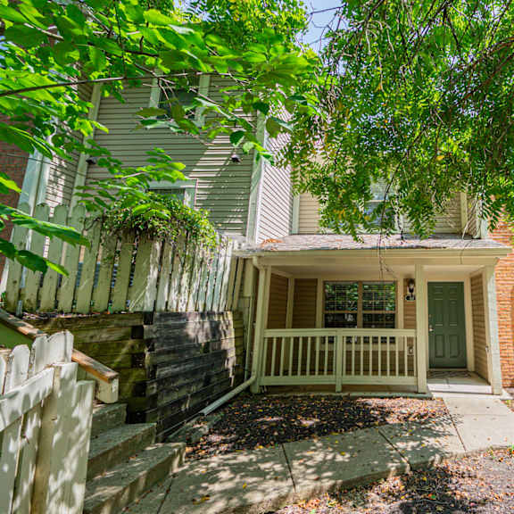 front entrance of a house with a porch and tree