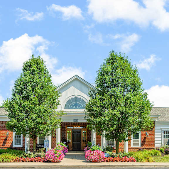 the front of a building with two trees in front of it
