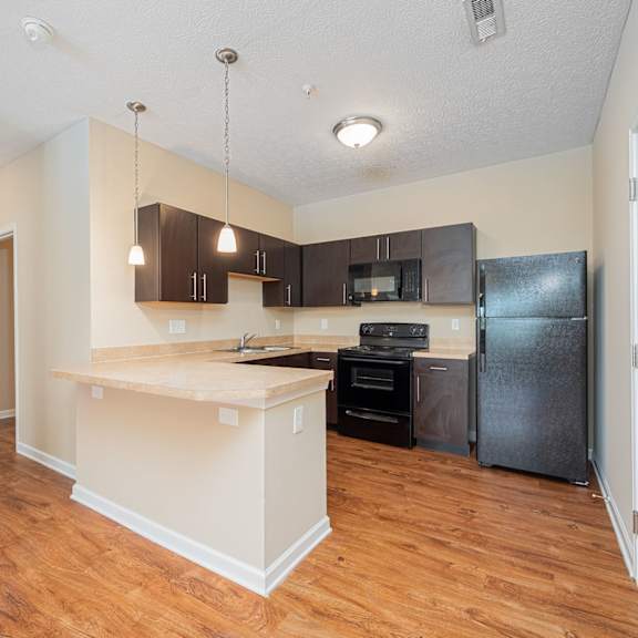 a kitchen with a large island and a black refrigerator