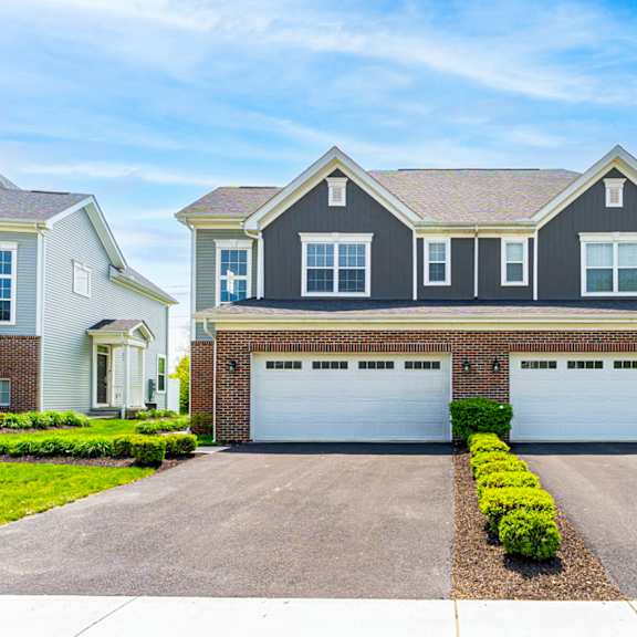 a two-car garage is in front of a house.