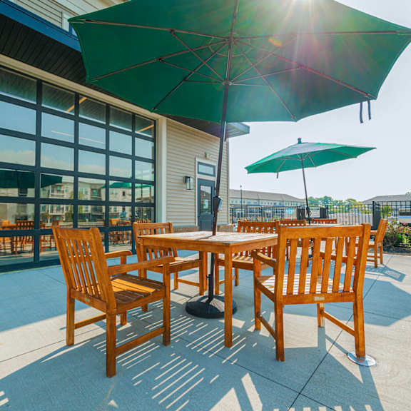 a patio with tables and umbrellas outside of a building