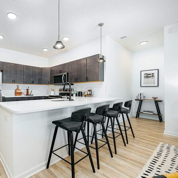 a kitchen with a large island with bar stools