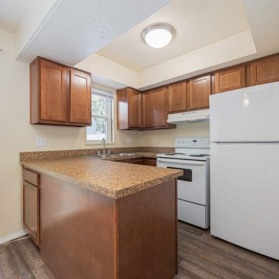a kitchen with white appliances and wooden cabinets.